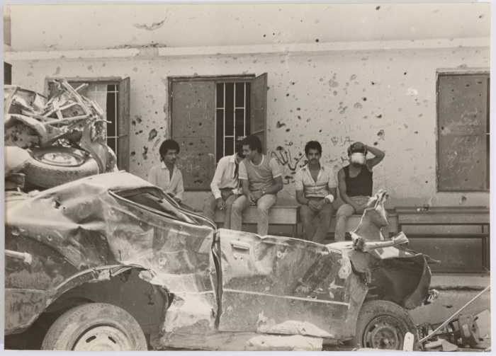 مجموعة من الرجال يشربون الشاي وأمامهم  مركبات مدمرة 