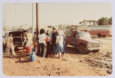 مجموعة من اللاجئين يحملون عبوات تخزين ملئت بالمياه قرب مخيم شاتيلا للاجئين