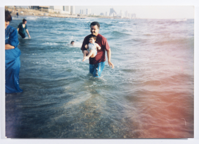 Ahmad al-Maslamany holding baby Wisam by the sea