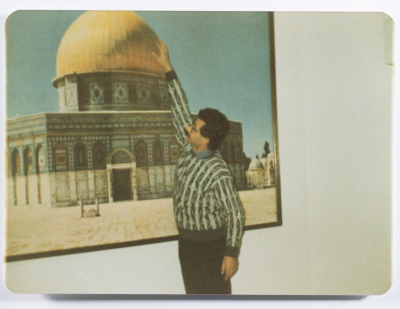 Ahmad al-Maslamany in front of a photo of the Dome of the Rock