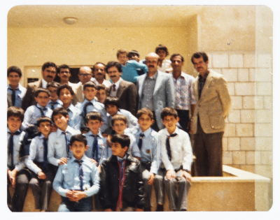 محمود شقير برفقة مجموعة من الطلبة والمعلمين في مدرسة إسكان الضُبّاط في عمّان عام 1984 